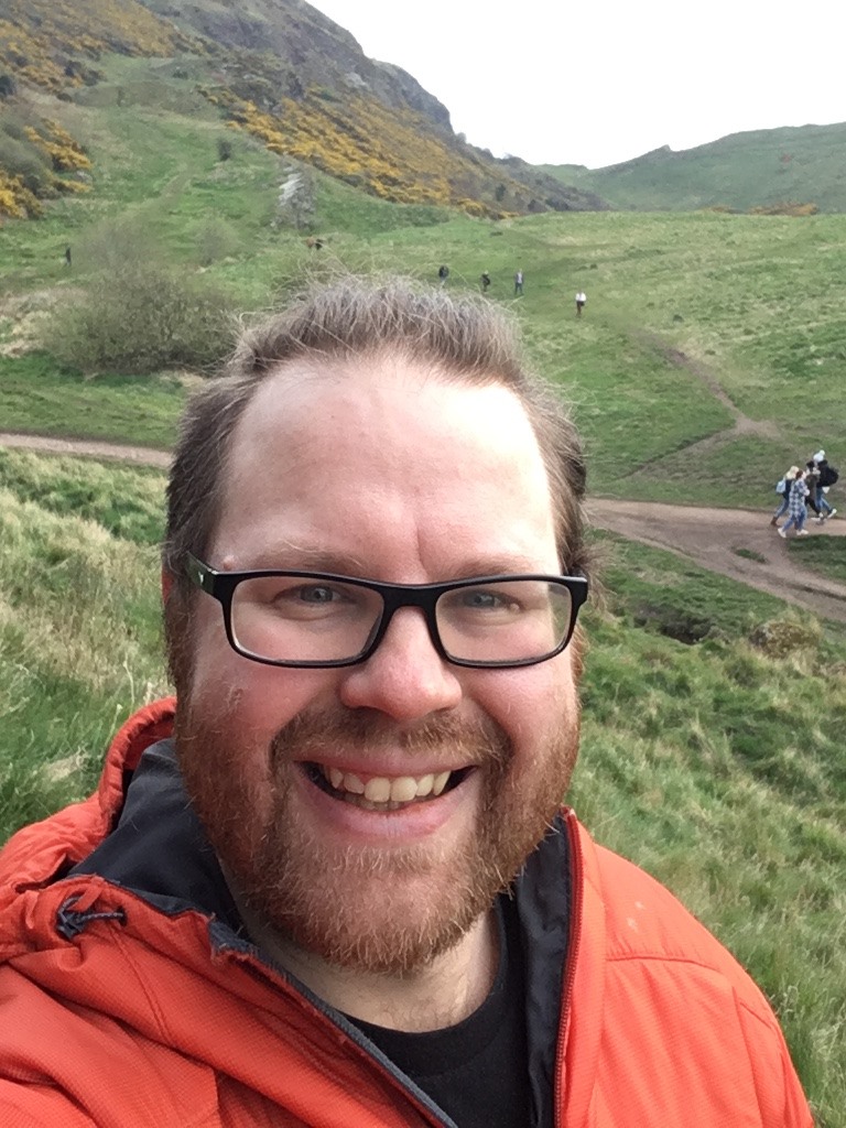 Portrait of Greg outdoors on a green hillside